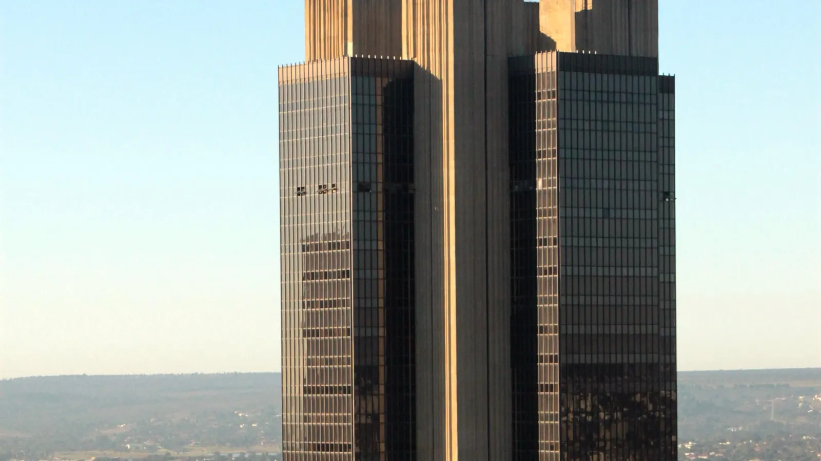 Torres de vidro escuro e concreto da sede do Banco Central do Brasil, em Brasília, sob céu claro