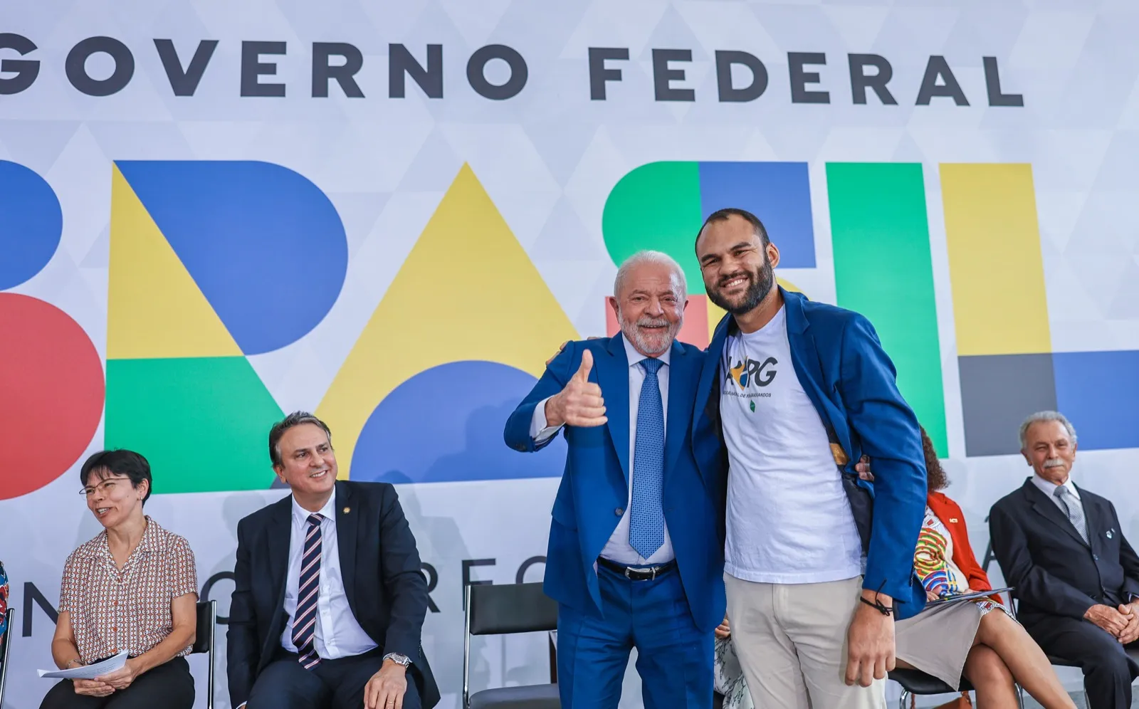 Lula e um estudante em evento do MEC, com o ministro Camilo Santana sentado ao fundo