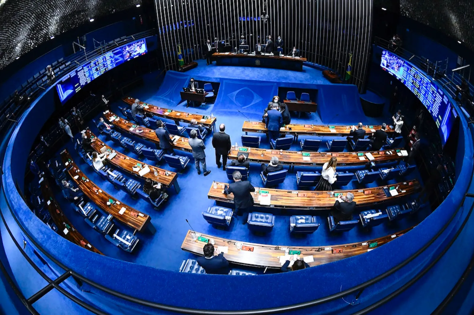 Vista elevada do plenário do Senado Federal, com parlamentares e bancadas semicirculares